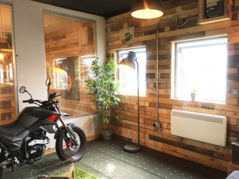 dimplex PXLE electric panel heater inside veterans garage on wooden wall by a house plant and across the room from a motor bike