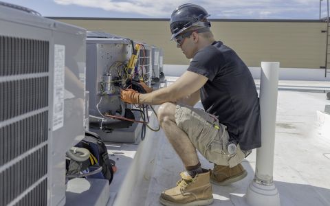man installing heatpump outdoors
