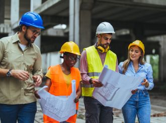 Group of architects and engineers discussing blueprint