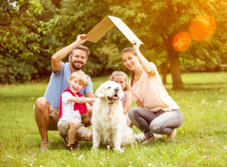 Glückliche Familie mit Hund im Garten