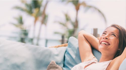 woman sitting happily on outdoor couch