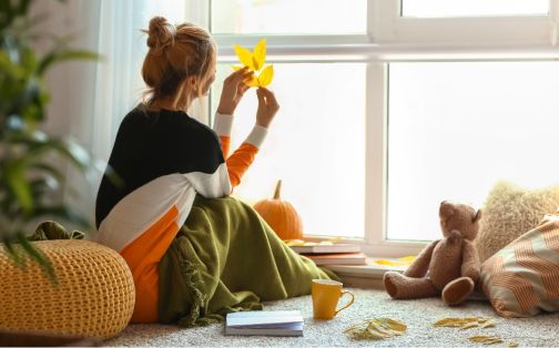 woman sat on floor in bedroom in autumn