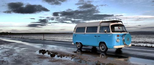 blue campervan driving on wet road