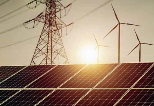 solar panels and wind turbines with sunset