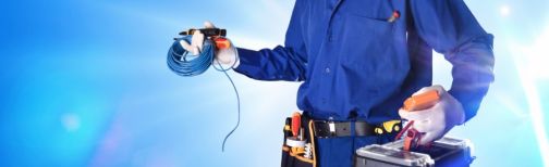 electrician in overalls holding tools and wiring
