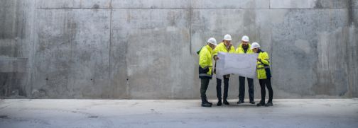engineers at building site with concrete wall