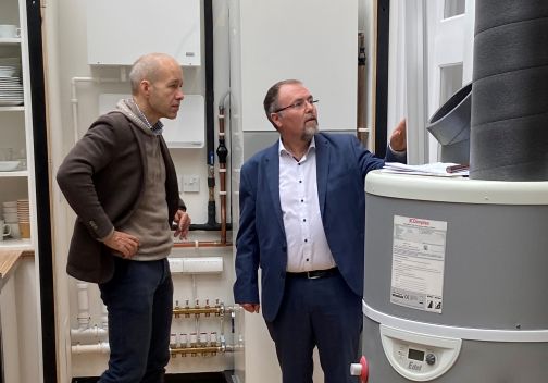 two men looking at the edel hot water heat pump from Dimplex