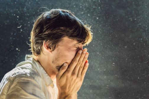 Man sneezing in dust