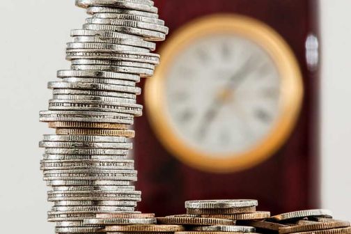 coins stacked in a tower next to a small pile of coins