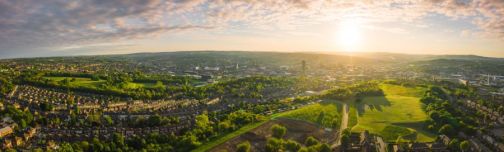 panoramic photo of landscape including houses and city in the distance