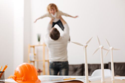 model wind farm on desk with father and child in background