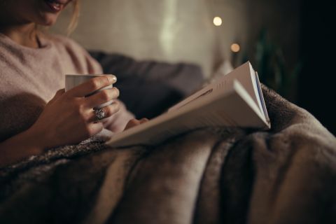 reading a book and wrapped in a blanket
