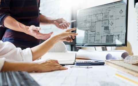 hands pointing to blueprint on screen