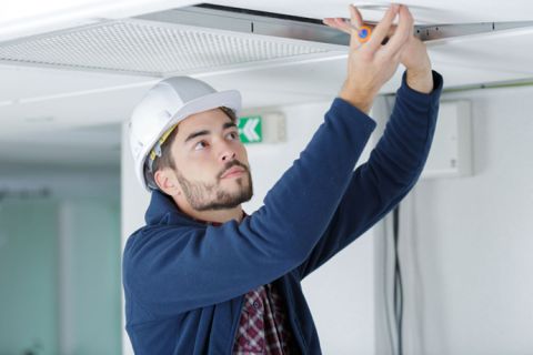 installer working on ceiling panel