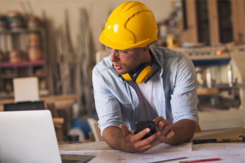 man in yellow hat looking up information