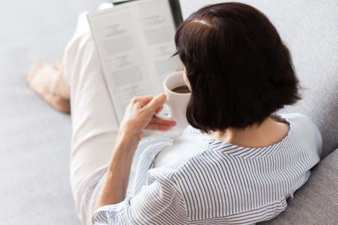 Woman reading and drinking coffee