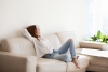 woman relaxing on sofa in a sunny room