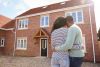 Couple stood in front of their home