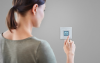 Frau stellt Temperatur Smart Home System ein